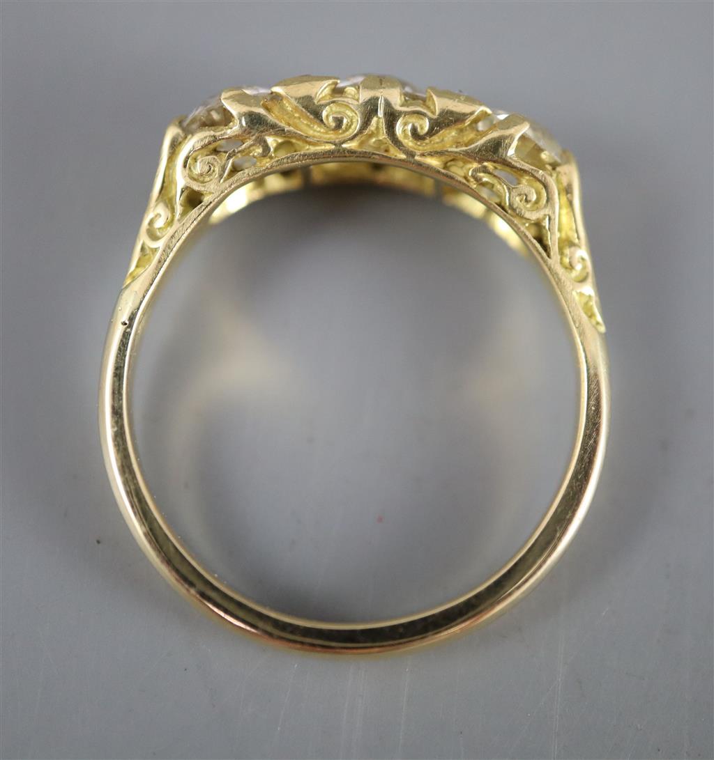 A Victorian style yellow metal and three stone diamond ring with diamond chip spacers, size Q, gross 4.5 grams.